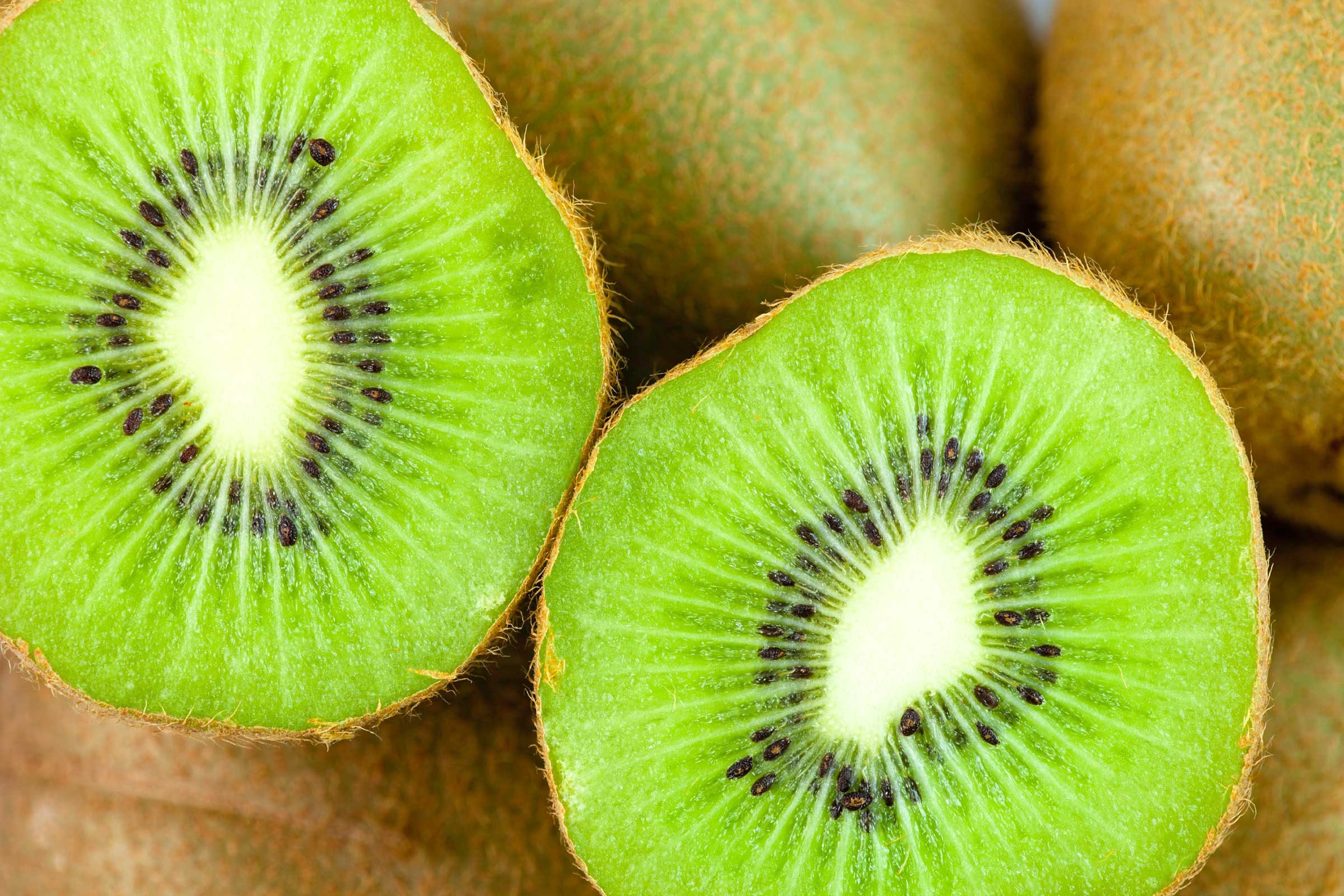 Cut a kiwifruit in half, then scoop out the flesh with a spoon