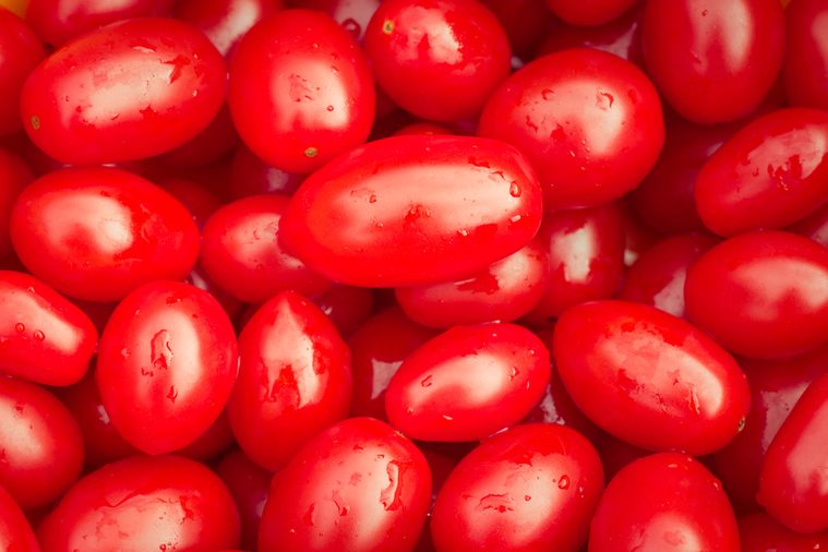 Just washed wet ripe tomatoes close up. Bright abstract background