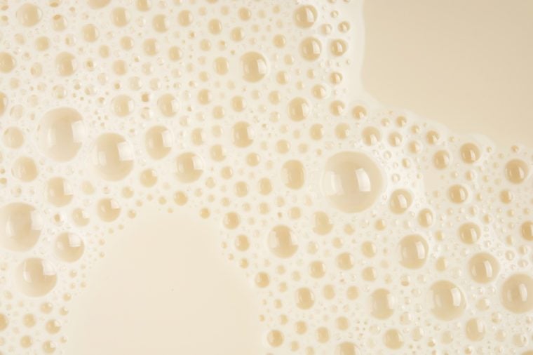 Soy milk bubble foam background on top view close up