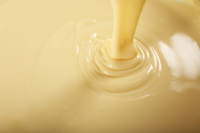 Background of condensed milk in a bowl, close-up