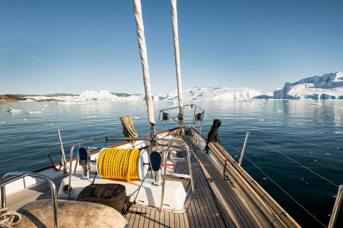 Deck of sailing ship, fjord, rear icebergs, Greenland