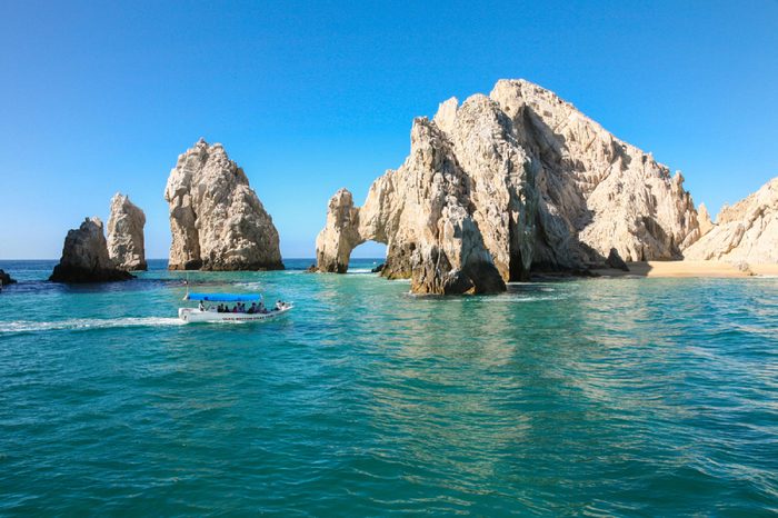 CABO SAN LUCAS, MEXICO -MARCH 20, 2012 : Boat with tourists approaching The Arch Cabo San Lucas, Mexico