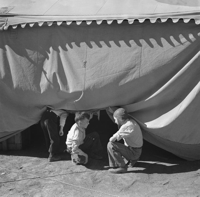 Children Sneaking Under Circus Tent
