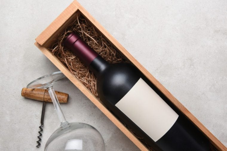 Red Wine Still Life: A bottle of wine in a wood case with glasses and corkscrew, with copy space.