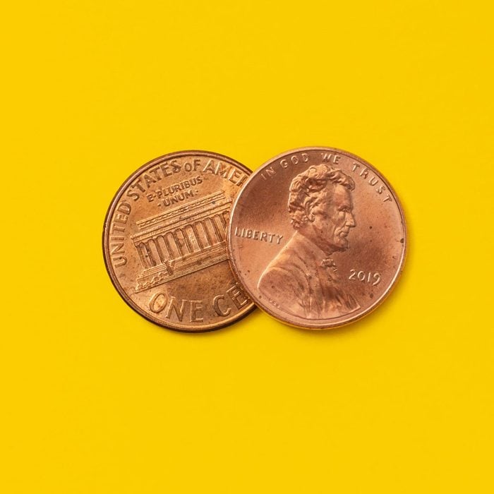 two pennies on a yellow background