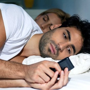 partner scrolling through phone while laying down