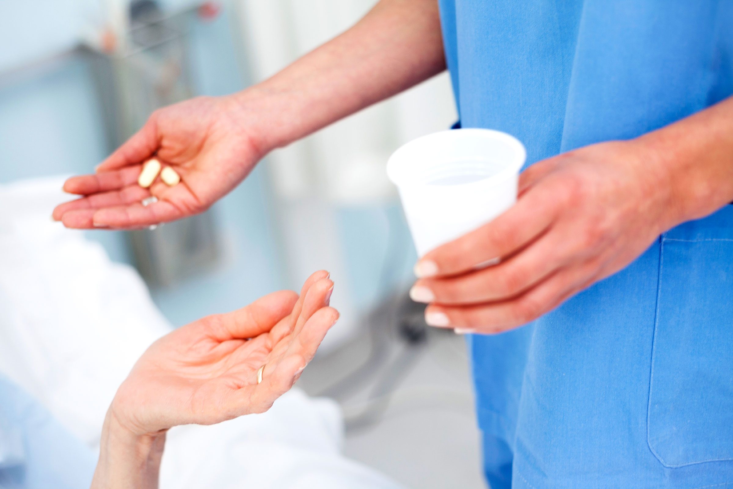 nursing handing patient pills and water