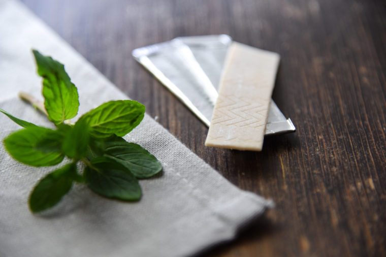 Chewing gums with mint leafs on wooden table