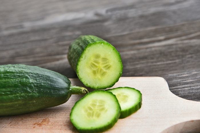 Cucumber seeds are edible and very nutritious. Fresh Cucumber slice on wooden board with wooden background.