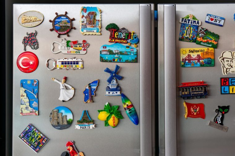 Lowicz, Poland - July 22, 2018: Mix of magnet from different countries and cities attached on a fridge. Those souvenirs are collected by many tourists after spending vacation.
