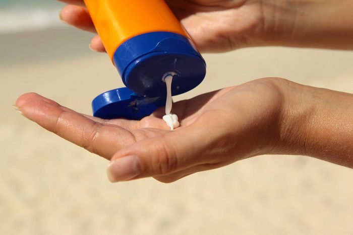close up of hands squeezing sunscreen into one hand