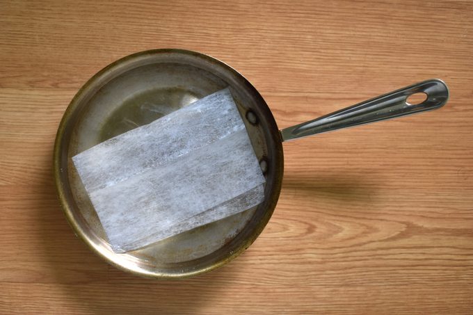 dryer sheet soaking in pan with water to help clean off burnt on food