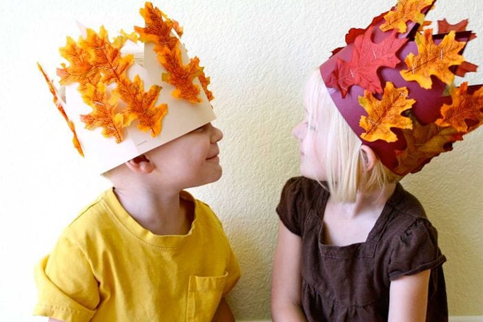 kids wearing harvest crowns they made for thanksgiving