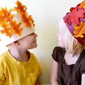 kids wearing harvest crowns they made for thanksgiving