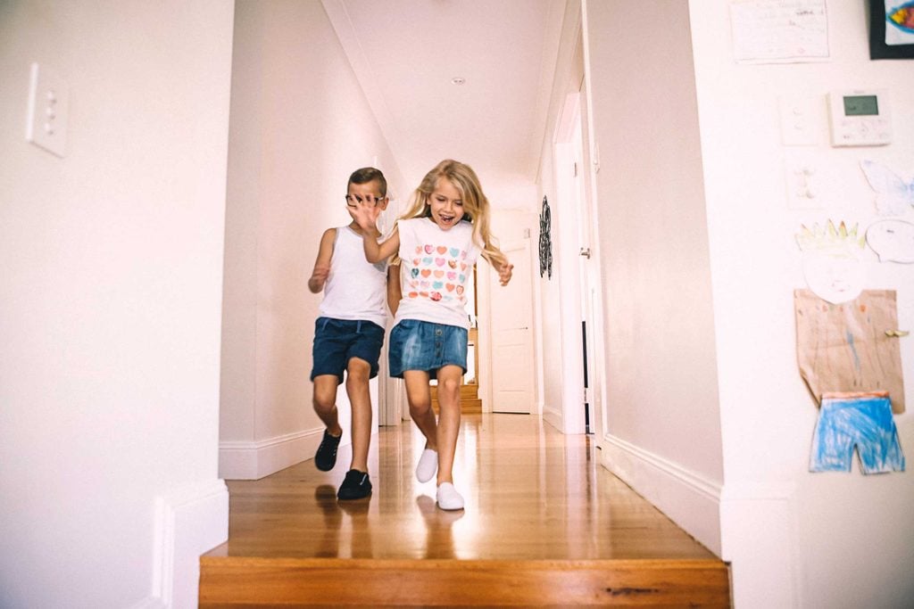 Two kids running through the house on a scavenger hunt