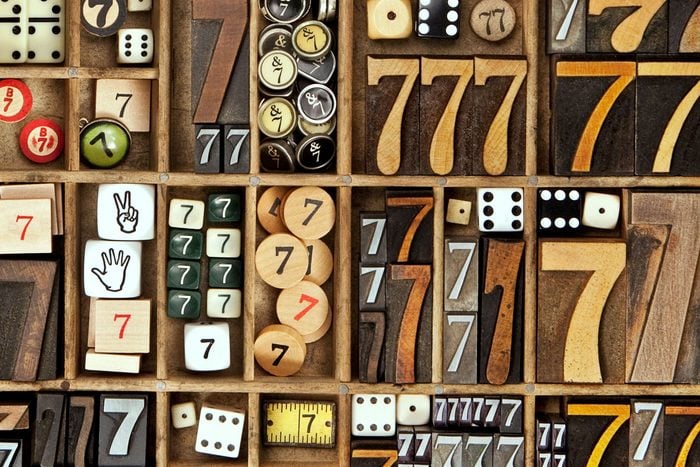 a collection many wooden number sevens and lucky dice in a letterpress drawer