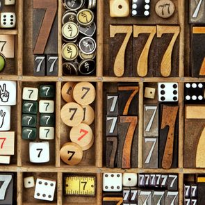 a collection many wooden number sevens and lucky dice in a letterpress drawer