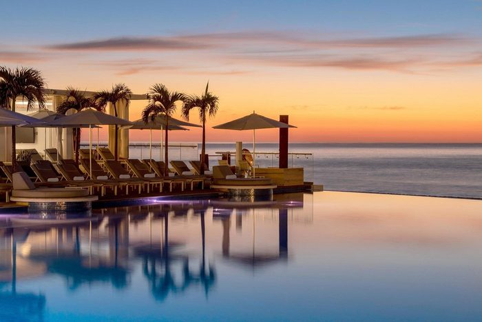 infinity pool with view of the sunset at le blanc spa resort