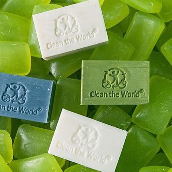 four bars of soap that say "clean the world" on a background of there unlabeled green bars of soap