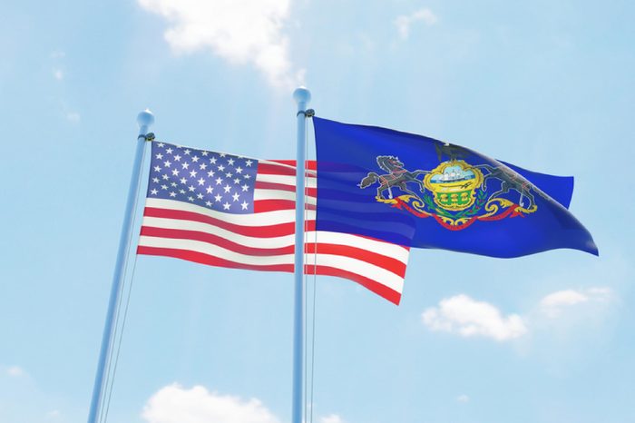 USA and state Pennsylvania, two flags waving against blue sky. 3d image