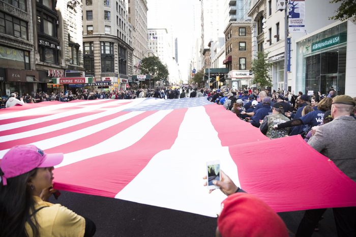 NEW YORK - 11 NOV 2016: Vets and military personnel carry a large American Flag from TheGroundZeroFlag.com in the annual Americas Parade up 5th Avenue on Veterans Day in Manhattan.