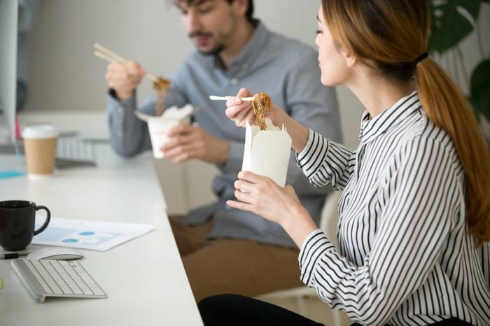 Office people eating chinese noodles holding boxes at lunch time, young woman and man employees enjoy japanese thai meal, colleagues tasting asian food at workplace, takeaway delivery service concept