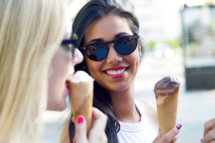 Outdoor portrait of beautiful young women having fun with ice cream.