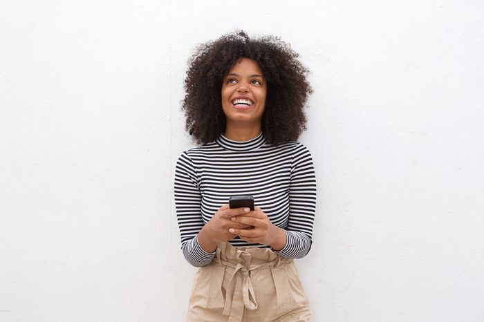 Portrait of happy african american woman holding smart phone