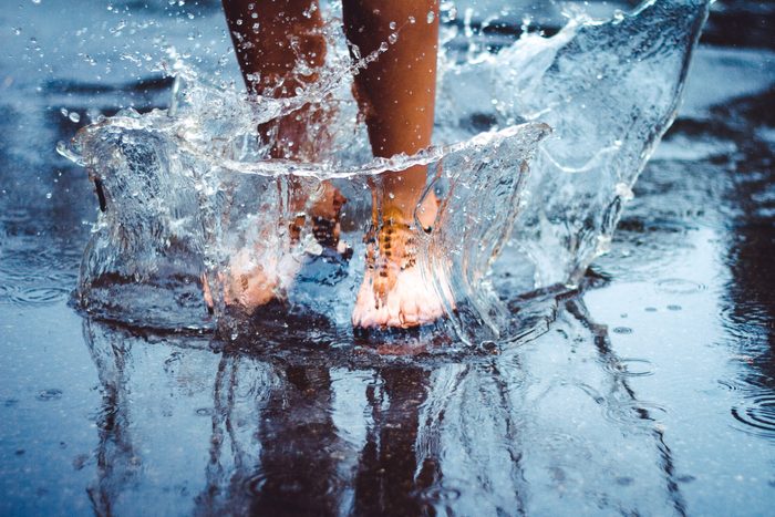 Unrecognizable person (female) is splashing water in a puddle on a rainy day in the city. Legs in puddle.; Shutterstock ID 405646975; Job (TFH, TOH, RD, BNB, CWM, CM): -