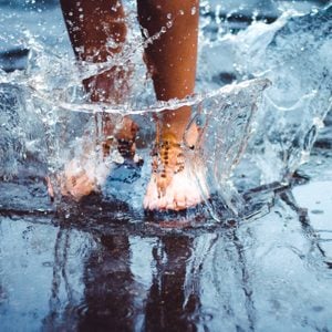 Unrecognizable person (female) is splashing water in a puddle on a rainy day in the city. Legs in puddle.; Shutterstock ID 405646975; Job (TFH, TOH, RD, BNB, CWM, CM): -