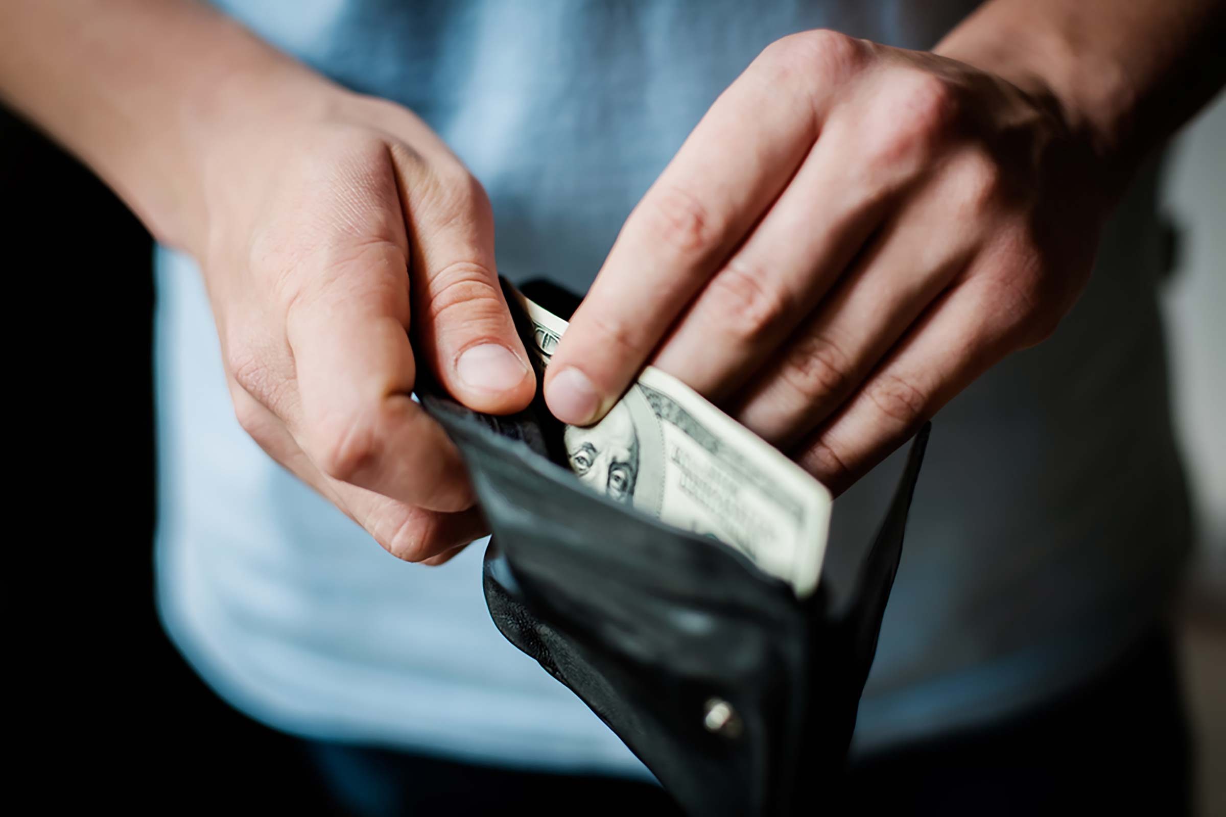 person taking money out of wallet