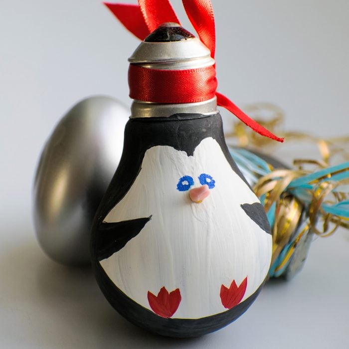 Ornament made out of a lightbulb with a penguin painted on