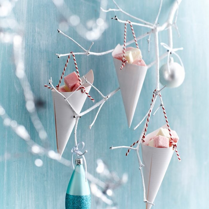 Coconut ice in paper cones hanging from painted white branch