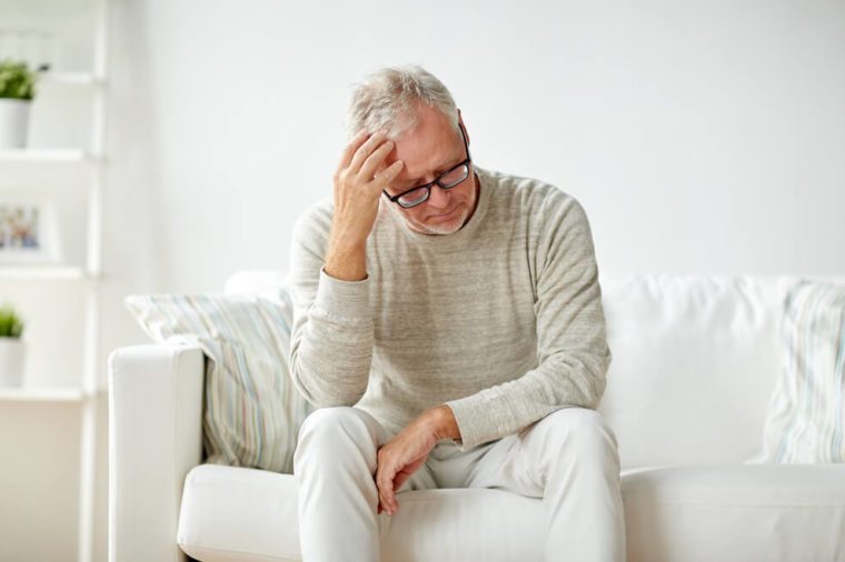 health, pain, stress, old age and people concept - senior man suffering from headache at home