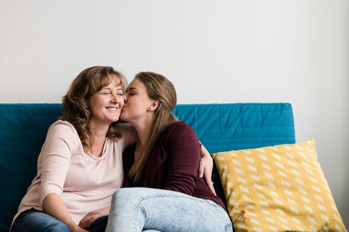 Affectionate teen daughter kissing her loving mother