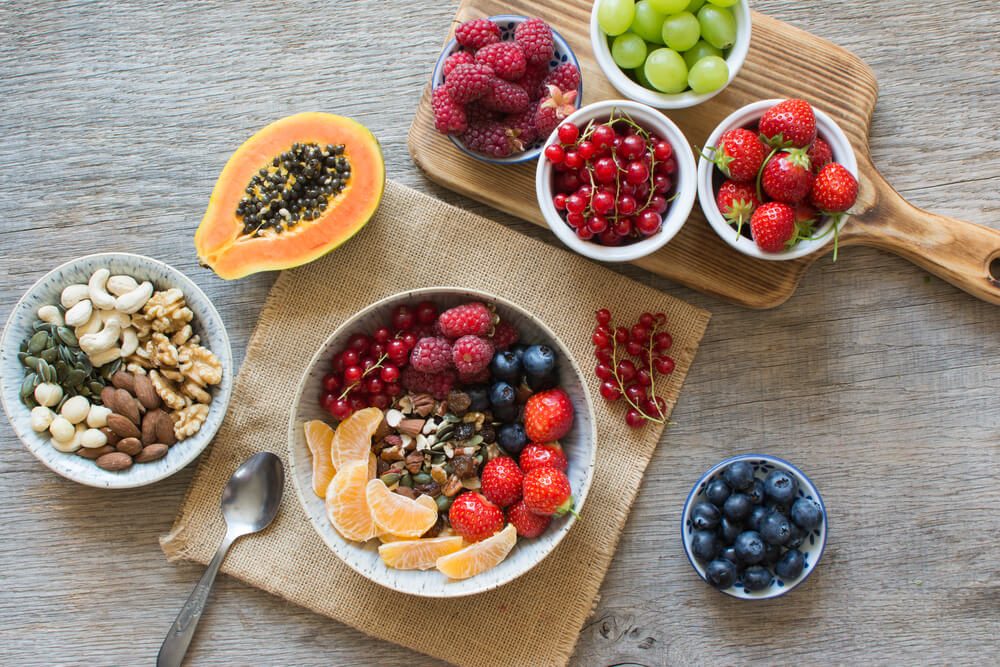 Overhead view of paleo style breakfast, grain free granola made with nuts and dried fruits, served with fresh berries, selective focus