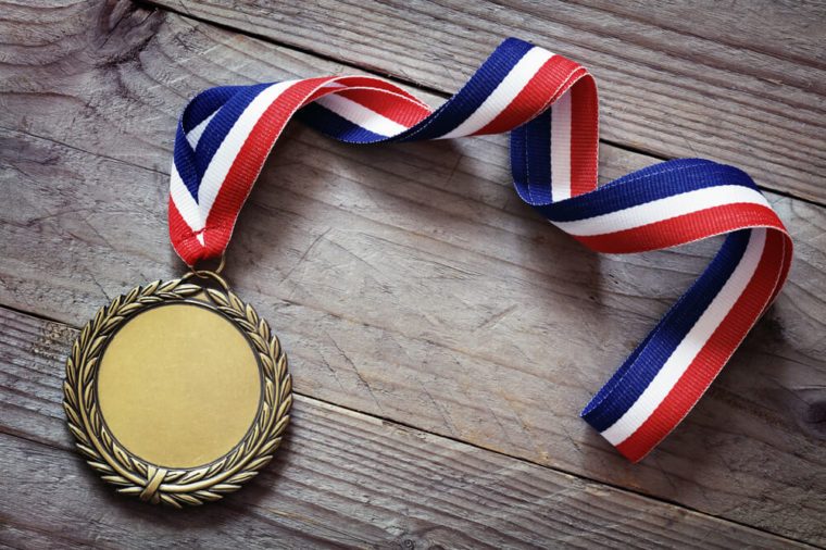 Gold medal on wood background with blank face for text, concept for winning or success