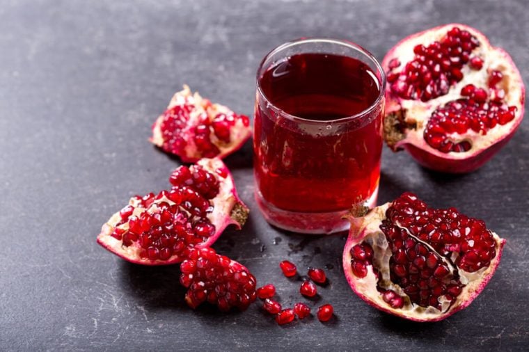 glass of pomegranate juice with fresh fruits on dark background.