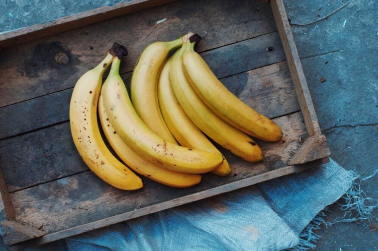 ripe yellow bananas in wicker basket,  on wooden background, view from above, yellow fruits, yellow bananas in a wooden box, food, meal, vitamins,