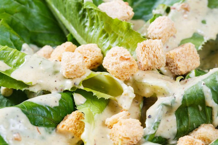 Close up croutons and cos vegetable on caesar salad dish