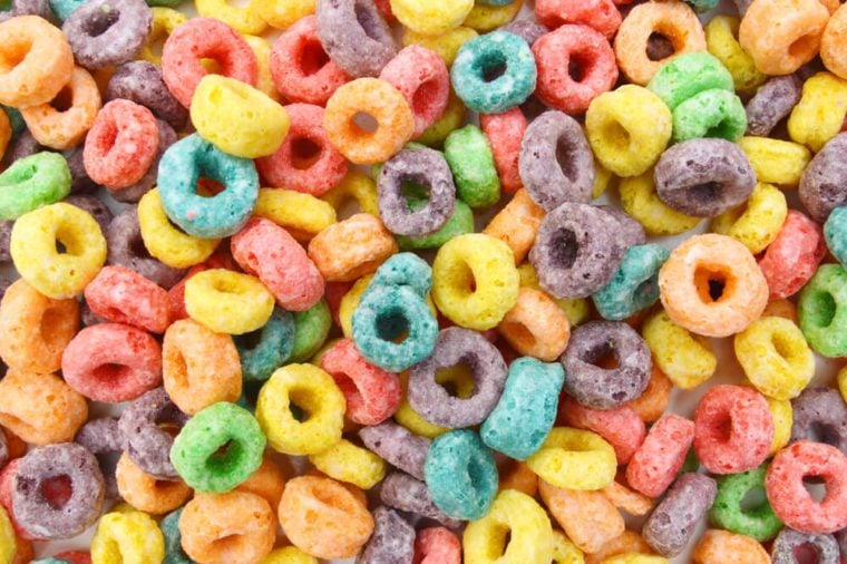 Delicious and nutritious fruit cereal loops flavorful on white background, healthy and funny addition to kids breakfast 