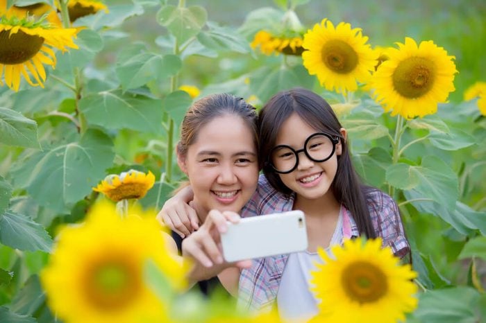 Asian mother and daughter taking selfie photograph together