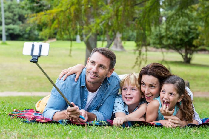 Happy family in the park taking selfie on a sunny day