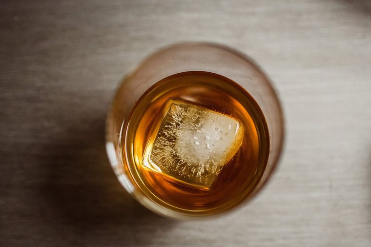 whiskey glass with ice cube from above