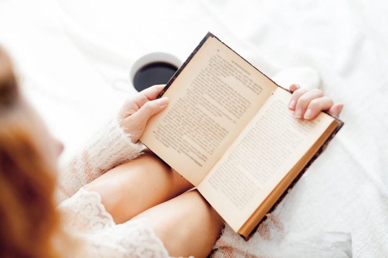 Soft photo of woman reading a book on the bed 