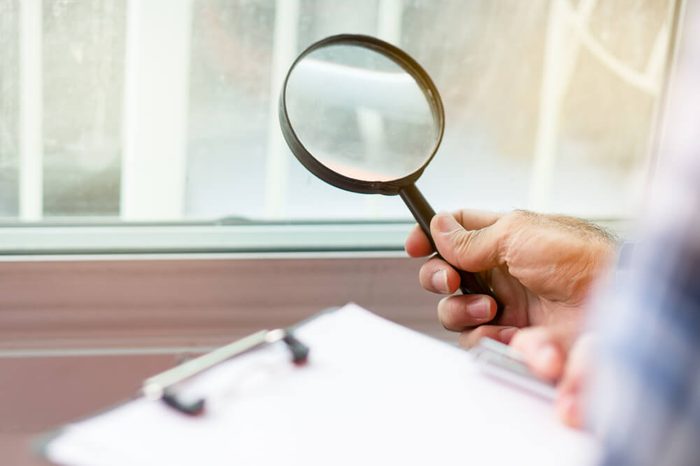 Inspection checklist review material property. Consultant house inspector holding Magnifying glass check material of property real estate for client before receive new house from agent.