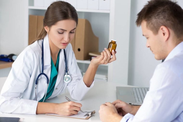 Female medicine doctor prescribing pills to her male patient. Healthcare, medical and pharmacy concept.