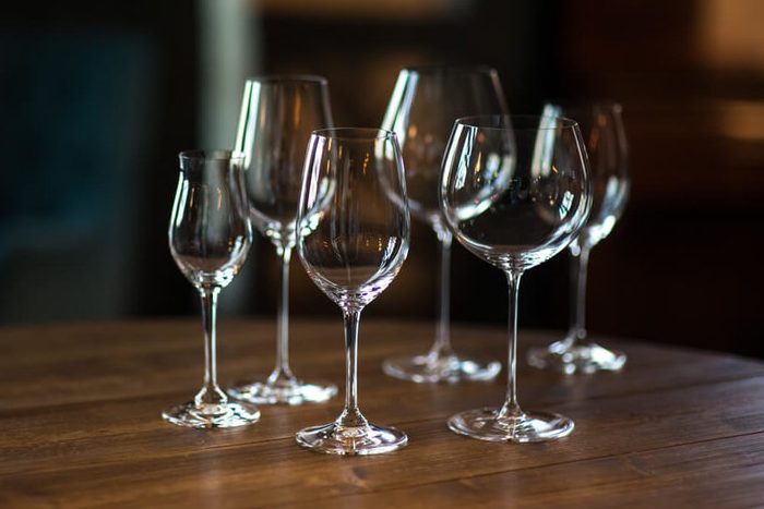 Different types of glasses for wine on wooden table. Still life concept.