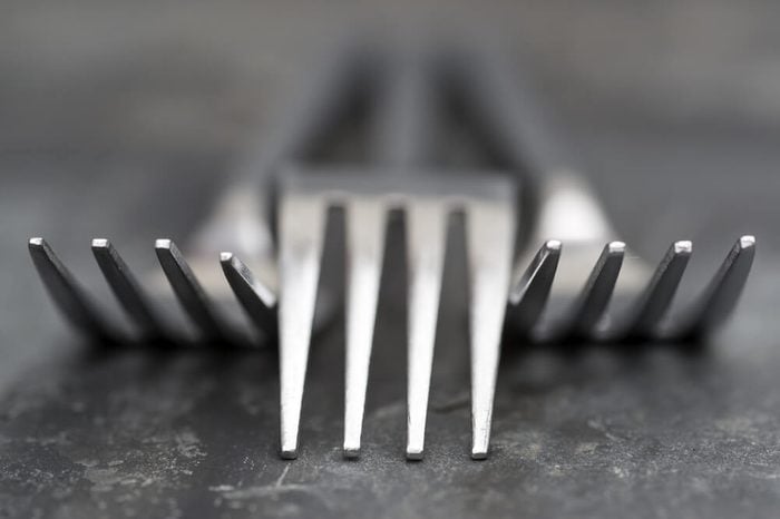 Macro image of modern cutlery forks on rustic slate background
