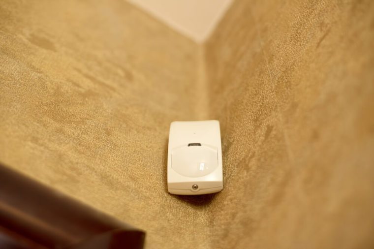 Motion sensor or detector for security system mounted on wall in a house